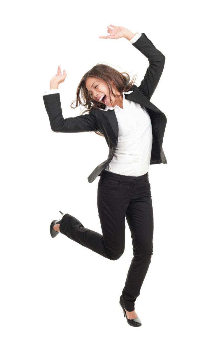 Joyful businesswoman in a black suit leaping with arms raised against a white background.