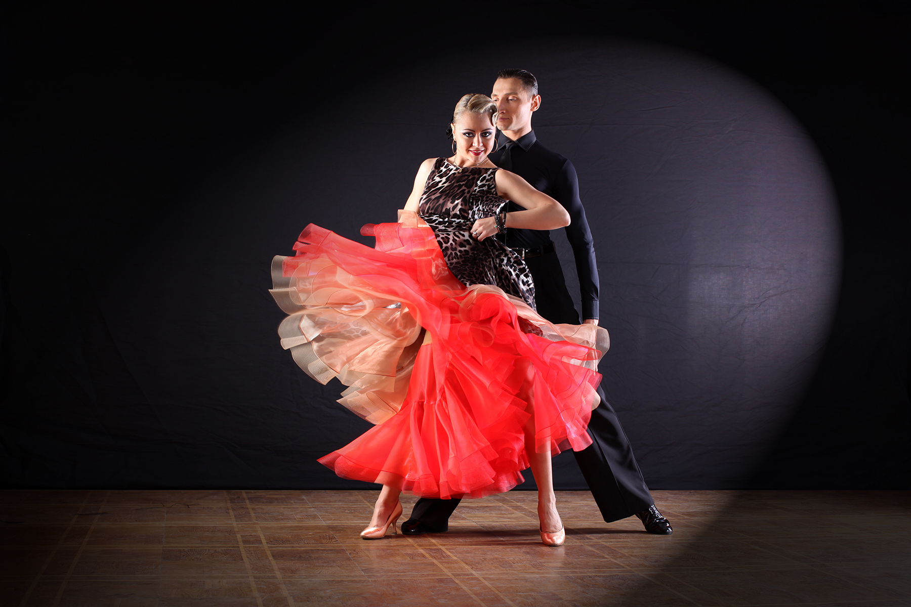 Professional ballroom dance couple performing on stage